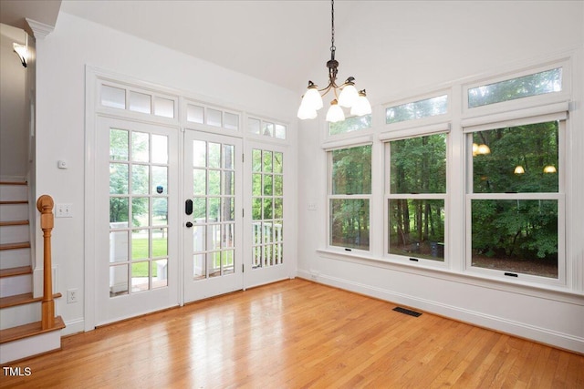 unfurnished sunroom featuring french doors and a chandelier