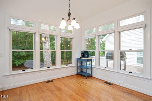 sunroom / solarium featuring a chandelier