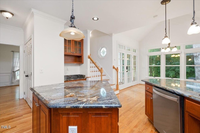 kitchen featuring stainless steel dishwasher, brown cabinets, light wood finished floors, dark stone countertops, and ornamental molding