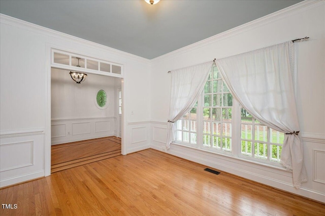 unfurnished dining area with wood finished floors, a chandelier, and ornamental molding