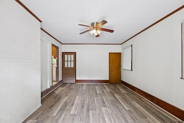330 Wilmot Dr, Raleigh, NC 27606 - spare room with crown molding, wood finished floors, a ceiling fan, baseboards, and brick wall
