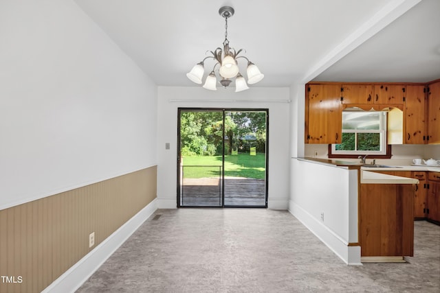 330 Wilmot Dr, Raleigh, NC 27606 - unfurnished dining area with a chandelier, baseboards, a sink, and wainscoting