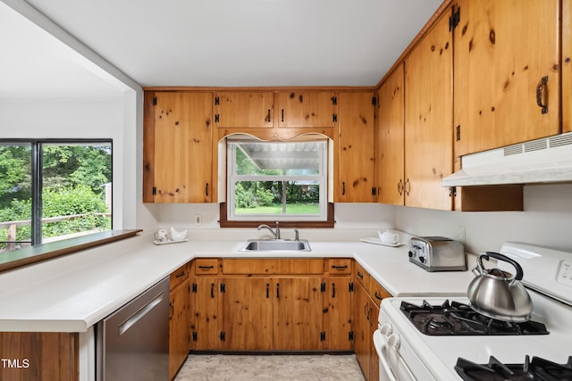 330 Wilmot Dr, Raleigh, NC 27606 - kitchen with white gas stove, stainless steel dishwasher, a sink, under cabinet range hood, and light countertops