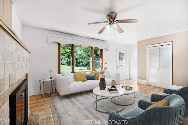 330 Wilmot Dr, Raleigh, NC 27606 - living area with a ceiling fan, light wood-type flooring, a brick fireplace, and baseboards