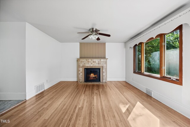 330 Wilmot Dr, Raleigh, NC 27606 - unfurnished living room featuring ceiling fan, light wood-style floors, a brick fireplace, and baseboards
