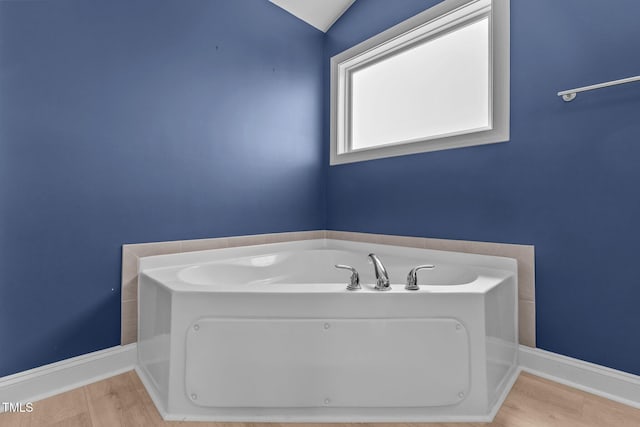 870 Kentucky Derby Ln, Lillington, NC 27546 - bathroom featuring wood finished floors, a bath, baseboards, and lofted ceiling