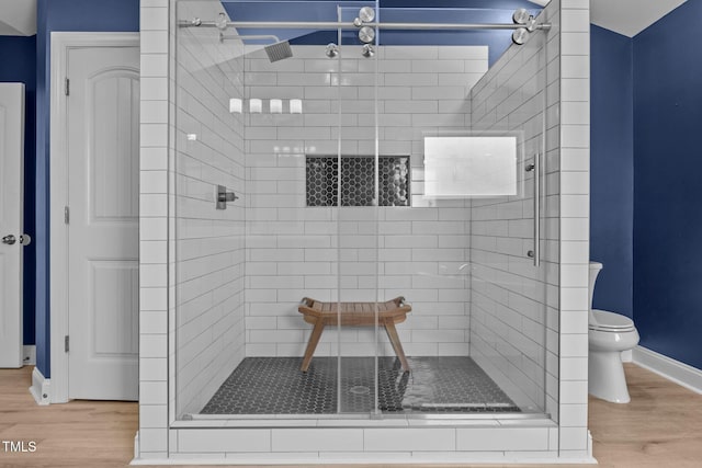 870 Kentucky Derby Ln, Lillington, NC 27546 - bathroom featuring wood finished floors, baseboards, toilet, and a stall shower