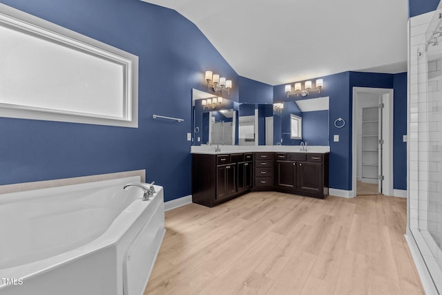 870 Kentucky Derby Ln, Lillington, NC 27546 - full bath featuring vaulted ceiling, a garden tub, wood finished floors, double vanity, and baseboards