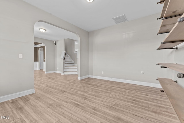 870 Kentucky Derby Ln, Lillington, NC 27546 - unfurnished room with arched walkways, stairway, light wood-style flooring, and baseboards