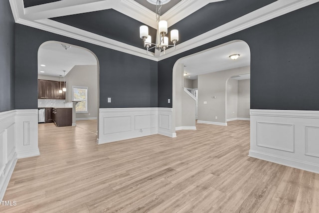 870 Kentucky Derby Ln, Lillington, NC 27546 - unfurnished dining area featuring arched walkways, a chandelier, light wood-style floors, a wainscoted wall, and crown molding