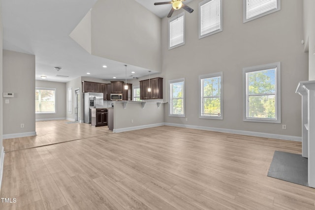 870 Kentucky Derby Ln, Lillington, NC 27546 - unfurnished living room with a ceiling fan, light wood finished floors, baseboards, recessed lighting, and a high ceiling