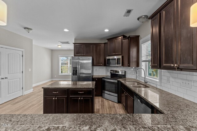 870 Kentucky Derby Ln, Lillington, NC 27546 - kitchen featuring stainless steel appliances, a sink, dark stone countertops, light wood-style flooring, and recessed lighting