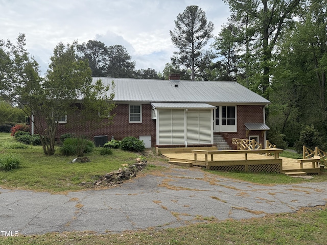 420 Rodwell St, Warrenton, NC 27589 - rear view of property with a wooden deck, metal roof, brick siding, central air condition unit, and asphalt driveway