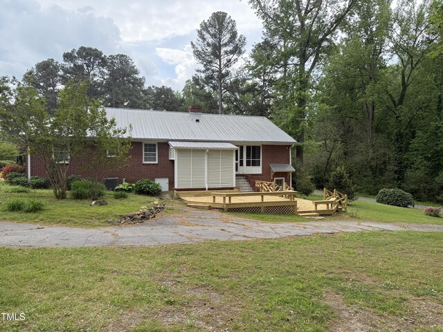 420 Rodwell St, Warrenton, NC 27589 - ranch-style house with a wooden deck, a front lawn, metal roof, brick siding, and central AC