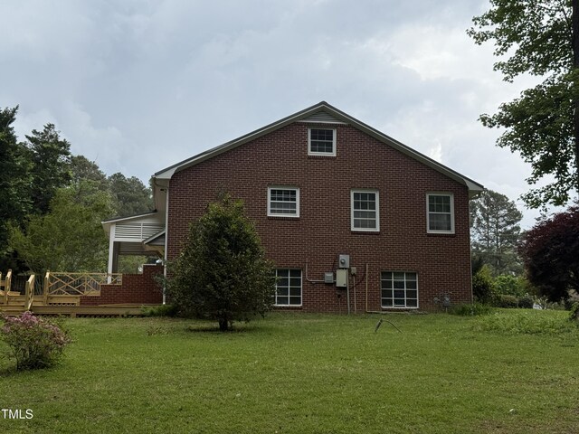 420 Rodwell St, Warrenton, NC 27589 - view of side of home featuring a lawn, brick siding, and a deck