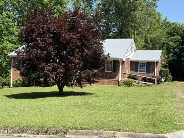420 Rodwell St, Warrenton, NC 27589 - view of front of house with brick siding, a front lawn, and metal roof
