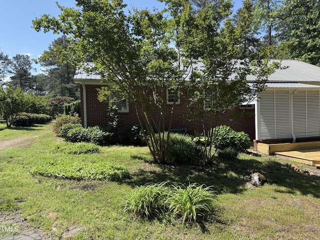 420 Rodwell St, Warrenton, NC 27589 - view of side of home with brick siding, a lawn, and metal roof