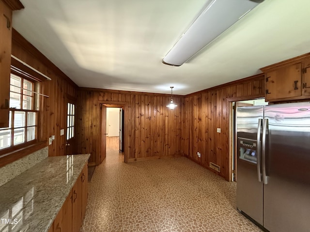 420 Rodwell St, Warrenton, NC 27589 - kitchen with stainless steel fridge with ice dispenser, wooden walls, light floors, baseboards, and pendant lighting