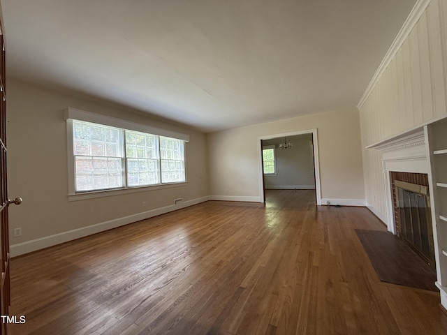 420 Rodwell St, Warrenton, NC 27589 - unfurnished living room with a chandelier, dark wood-style flooring, a fireplace, and baseboards