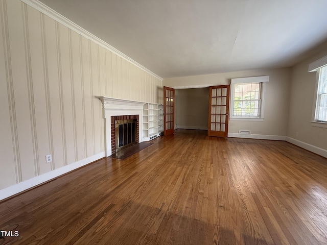 420 Rodwell St, Warrenton, NC 27589 - unfurnished living room featuring wood finished floors, baseboards, and a brick fireplace