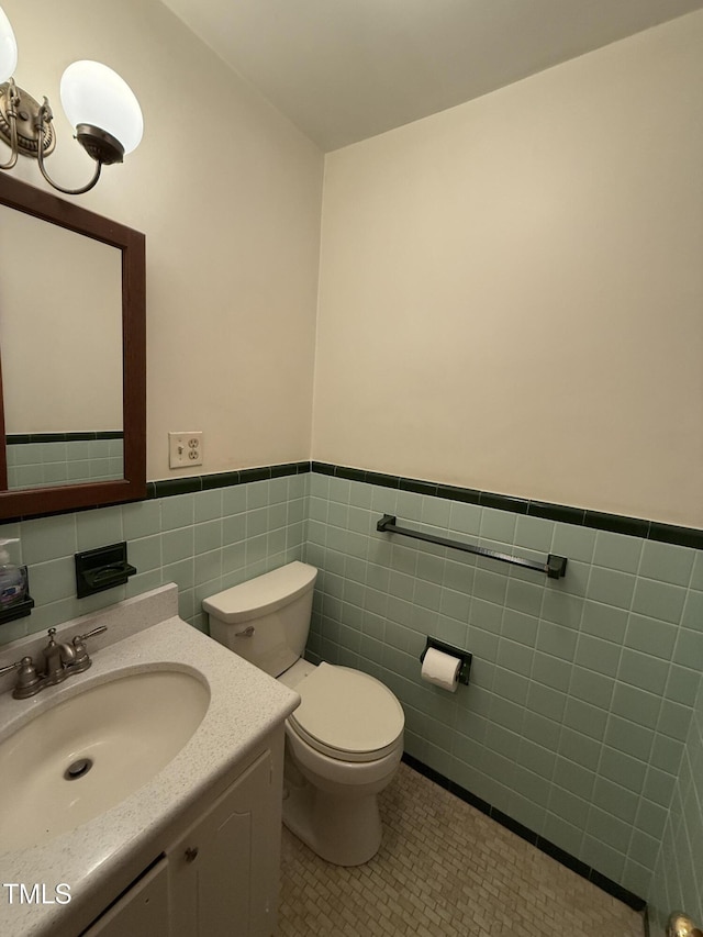 420 Rodwell St, Warrenton, NC 27589 - bathroom with tile walls, toilet, wainscoting, tile patterned floors, and vanity