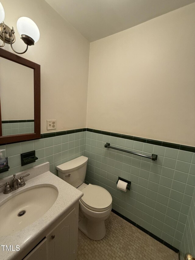 420 Rodwell St, Warrenton, NC 27589 - bathroom with tile walls, toilet, wainscoting, tile patterned floors, and vanity