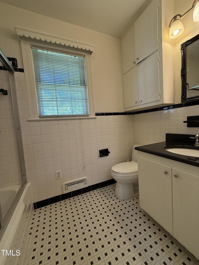 420 Rodwell St, Warrenton, NC 27589 - bathroom featuring tile walls, toilet, tile patterned floors, vanity, and a wainscoted wall