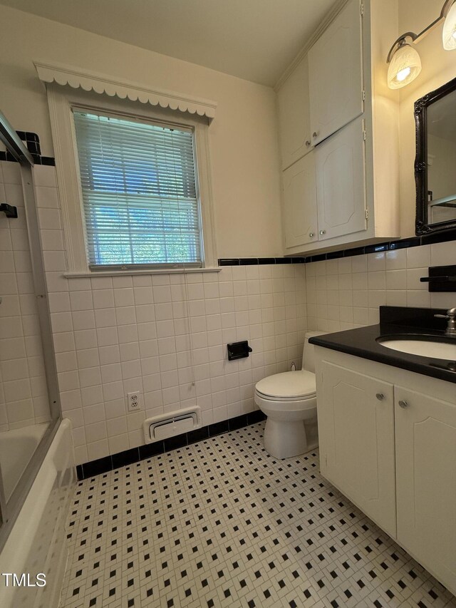 420 Rodwell St, Warrenton, NC 27589 - bathroom featuring tile walls, toilet, tile patterned floors, vanity, and a wainscoted wall