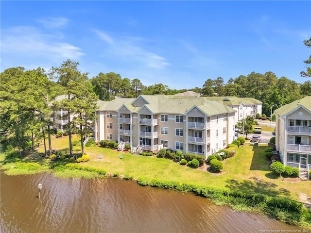 bird's eye view of apartment complex / building, a large body of water, and a tree filled landscape