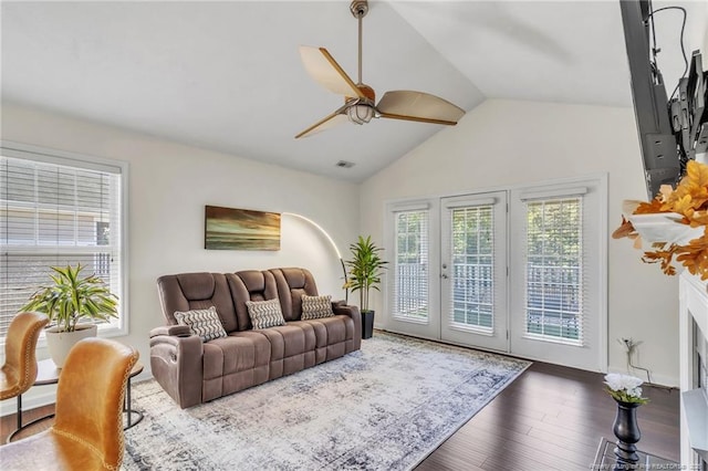 living area with ceiling fan, lofted ceiling, wood finished floors, and french doors