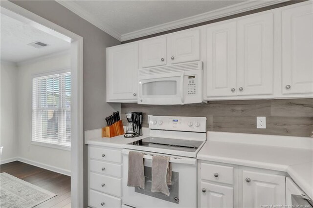 kitchen featuring white appliances, wood finished floors, crown molding, white cabinetry, and light countertops