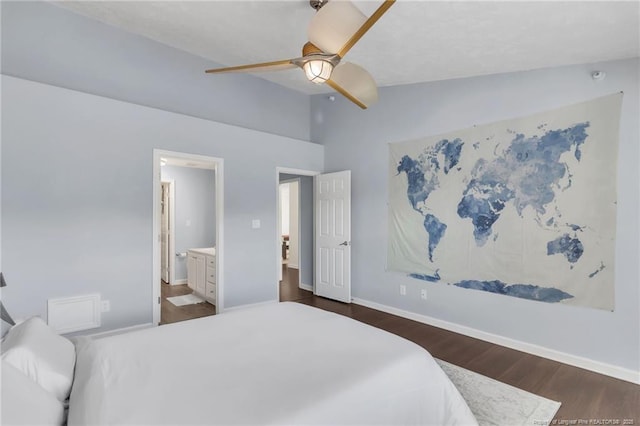 bedroom featuring dark wood-style floors, vaulted ceiling, baseboards, ensuite bathroom, and ceiling fan