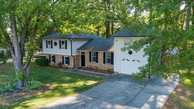split level home featuring driveway, brick siding, an attached garage, and a front yard