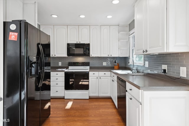 kitchen featuring black appliances, a sink, white cabinets, backsplash, and recessed lighting