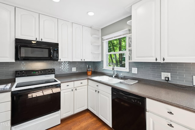 kitchen with black appliances, a sink, dark countertops, and recessed lighting