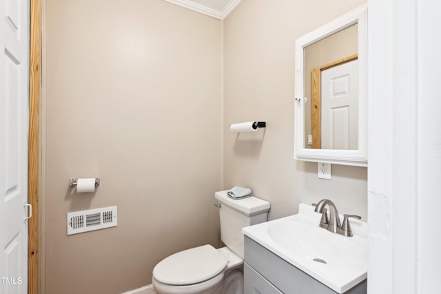 bathroom with vanity, toilet, and ornamental molding