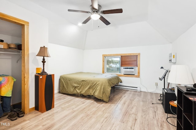 bedroom featuring lofted ceiling, baseboard heating, light wood-style flooring, cooling unit, and a wall mounted AC