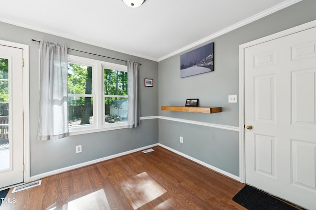 spare room featuring ornamental molding, dark wood finished floors, and baseboards