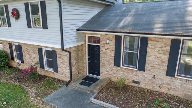 property entrance with brick siding and crawl space