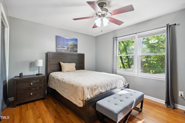 bedroom with light wood-style flooring, baseboards, and a ceiling fan