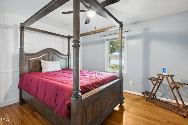 bedroom with wood finished floors, baseboards, and a ceiling fan
