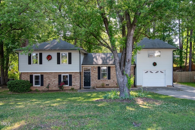 tri-level home with driveway, a garage, and brick siding
