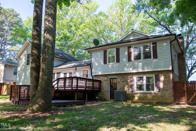 back of house featuring cooling unit, a wooden deck, and brick siding