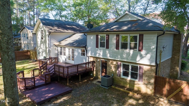 rear view of property featuring central air condition unit, fence, a wooden deck, a shingled roof, and french doors