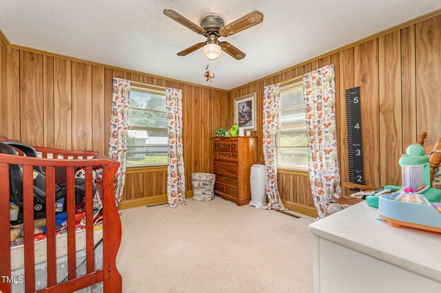 80 Lewis Moody Rd, Bear Creek, NC 27207 - bedroom featuring wood walls, baseboards, carpet, a textured ceiling, and a ceiling fan