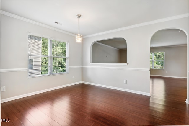 empty room featuring hardwood / wood-style flooring, baseboards, and ornamental molding