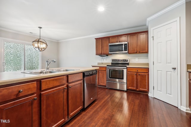 kitchen with appliances with stainless steel finishes, light countertops, dark wood-style flooring, a sink, and crown molding