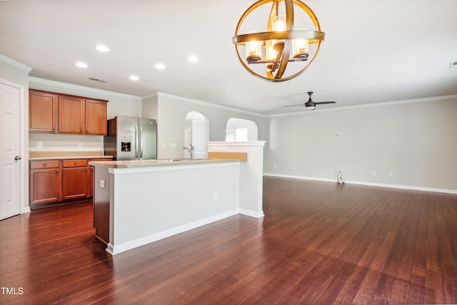kitchen with stainless steel refrigerator with ice dispenser, a chandelier, light countertops, brown cabinetry, and a ceiling fan