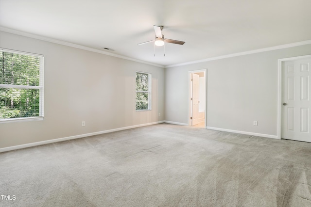carpeted spare room featuring a ceiling fan, ornamental molding, and baseboards