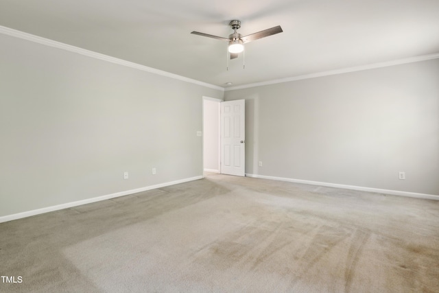 spare room with crown molding, a ceiling fan, baseboards, and carpet flooring